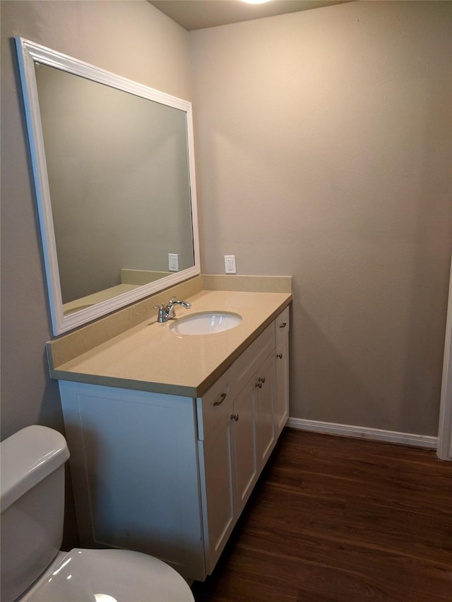 bathroom featuring toilet, vanity, and hardwood / wood-style flooring