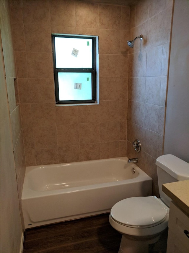 full bathroom featuring toilet, hardwood / wood-style floors, vanity, and tiled shower / bath combo