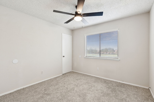 carpeted empty room with ceiling fan and a textured ceiling