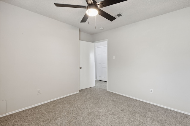 carpeted spare room with ceiling fan and a textured ceiling