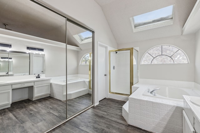 bathroom featuring vaulted ceiling with skylight, vanity, plus walk in shower, and a wealth of natural light