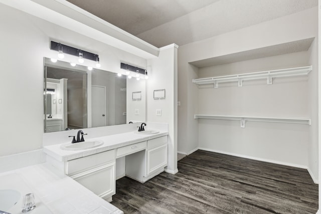 bathroom with crown molding, hardwood / wood-style floors, vanity, and a textured ceiling