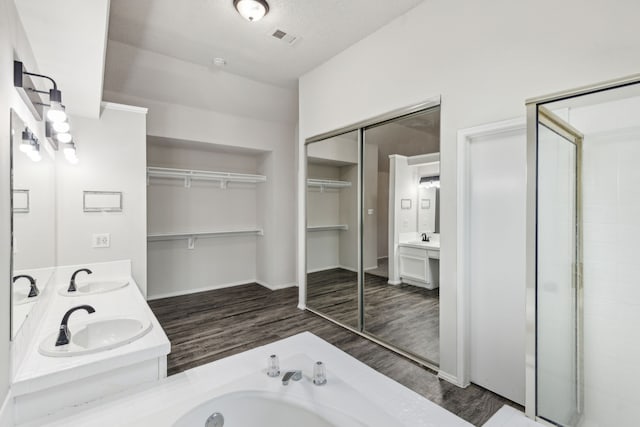 bathroom featuring vanity, independent shower and bath, a textured ceiling, and hardwood / wood-style flooring