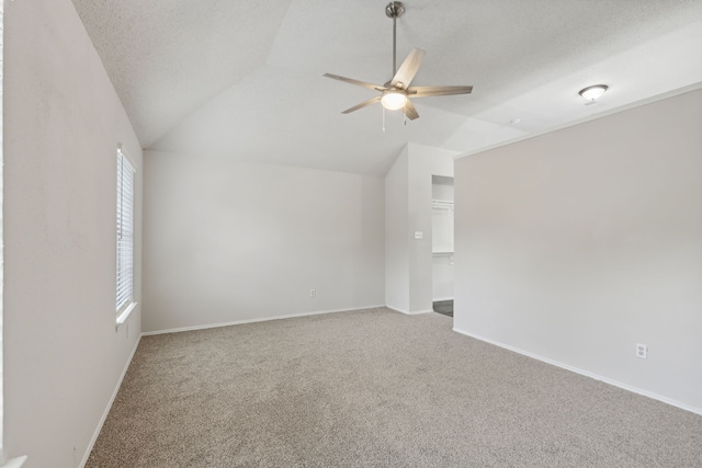 unfurnished room with ceiling fan, lofted ceiling, a textured ceiling, and carpet floors