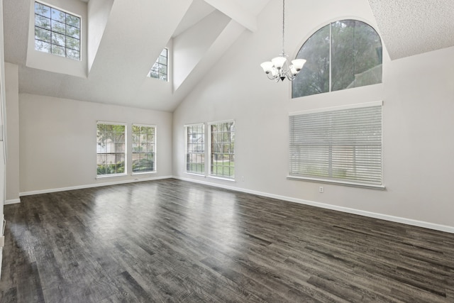 unfurnished living room with a textured ceiling, dark hardwood / wood-style flooring, a high ceiling, and an inviting chandelier