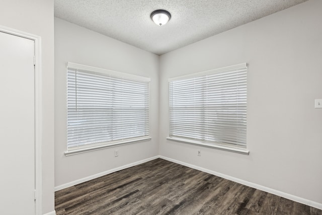 empty room with a textured ceiling and dark wood-type flooring