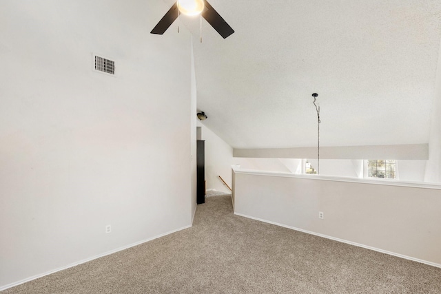 carpeted spare room featuring ceiling fan and lofted ceiling