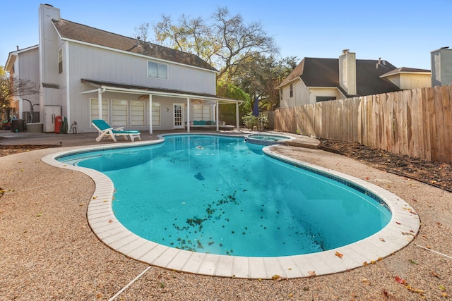 view of pool with an in ground hot tub, french doors, and a patio area