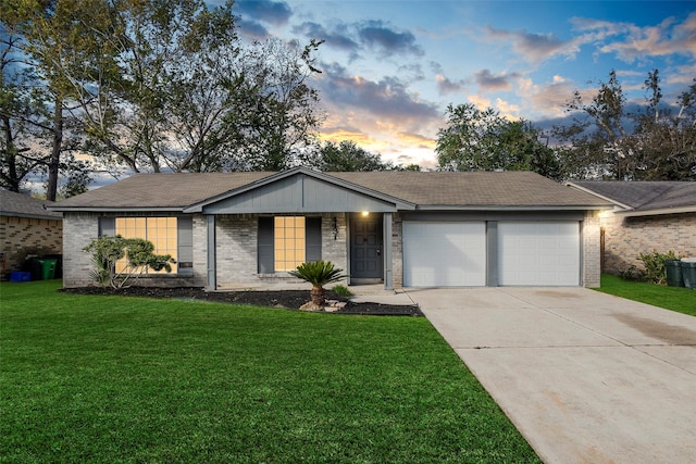 ranch-style home with a garage and a lawn