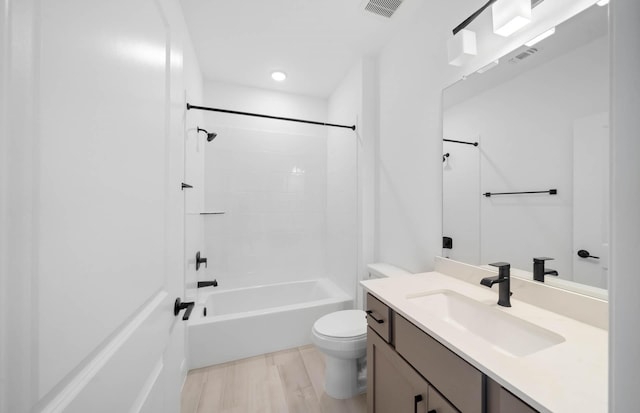 full bathroom featuring hardwood / wood-style floors, vanity, toilet, and tub / shower combination