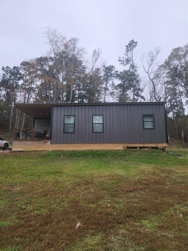 view of side of property featuring a yard and a deck