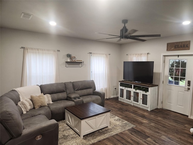 living room with ceiling fan and dark wood-type flooring