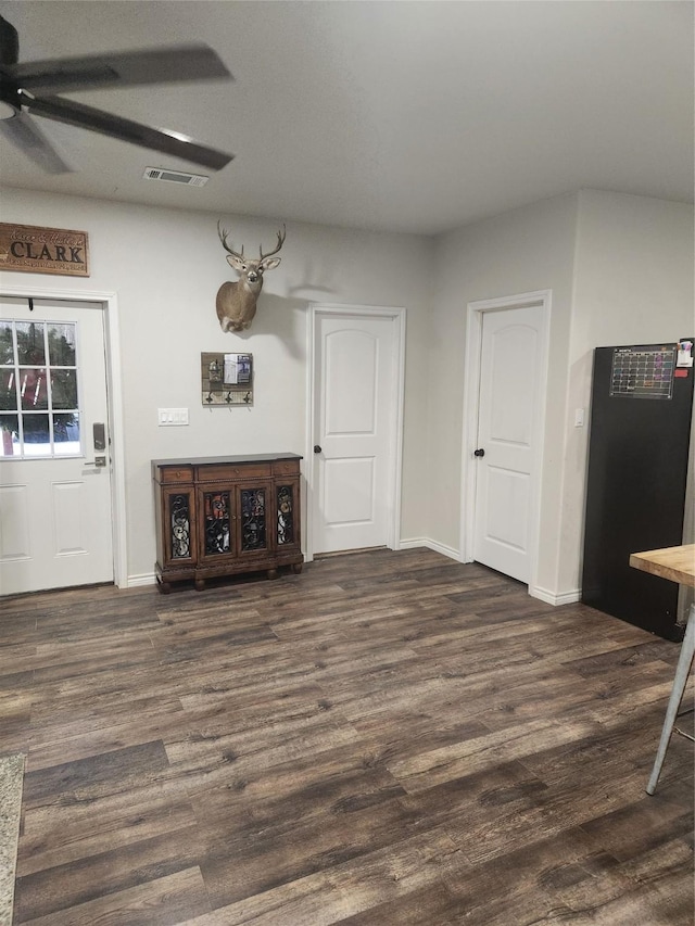 living room featuring ceiling fan and dark hardwood / wood-style flooring