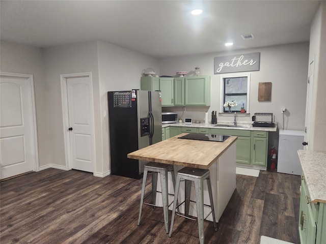 kitchen featuring sink, stainless steel appliances, dark hardwood / wood-style flooring, butcher block countertops, and green cabinetry