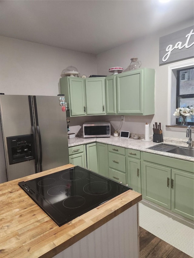 kitchen featuring butcher block counters, sink, stainless steel appliances, and green cabinetry