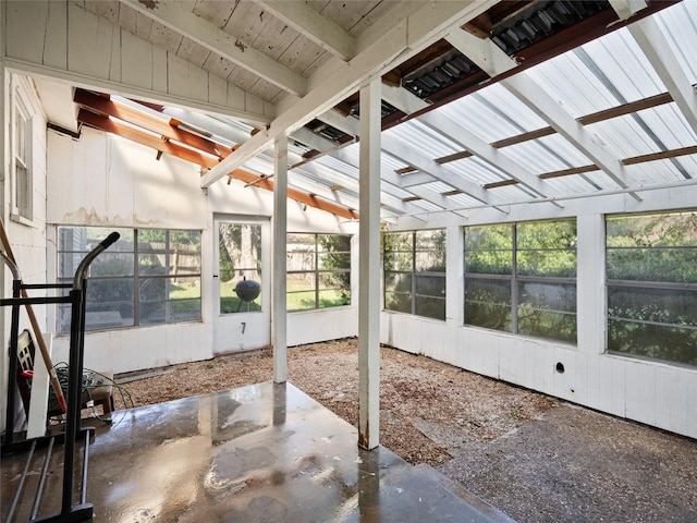 unfurnished sunroom featuring vaulted ceiling with beams