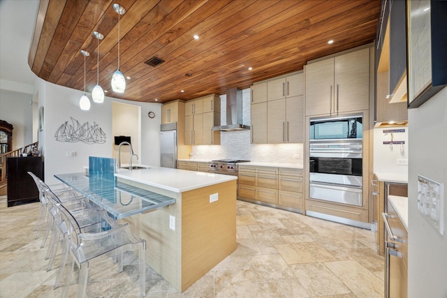 kitchen featuring backsplash, a center island with sink, built in appliances, wall chimney exhaust hood, and wood ceiling