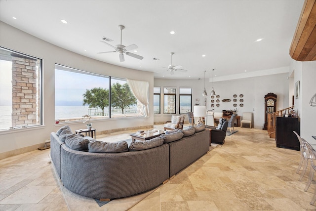 living room with ceiling fan and a water view