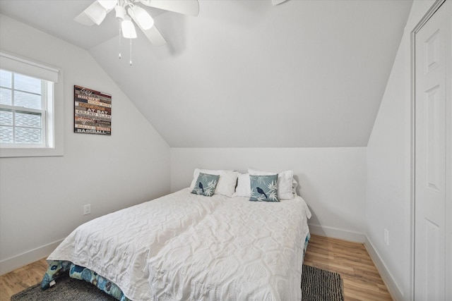 bedroom featuring hardwood / wood-style floors, ceiling fan, and lofted ceiling