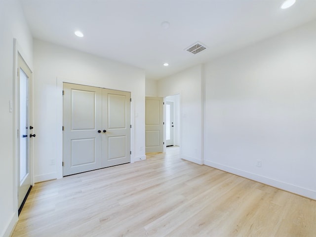 unfurnished bedroom featuring a closet and light hardwood / wood-style flooring