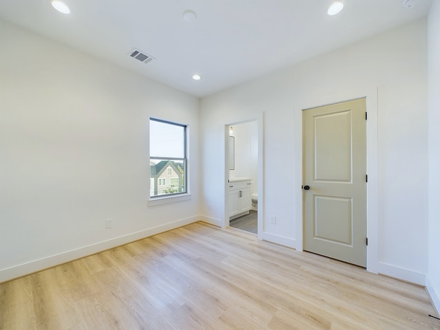 unfurnished bedroom featuring connected bathroom and light hardwood / wood-style flooring