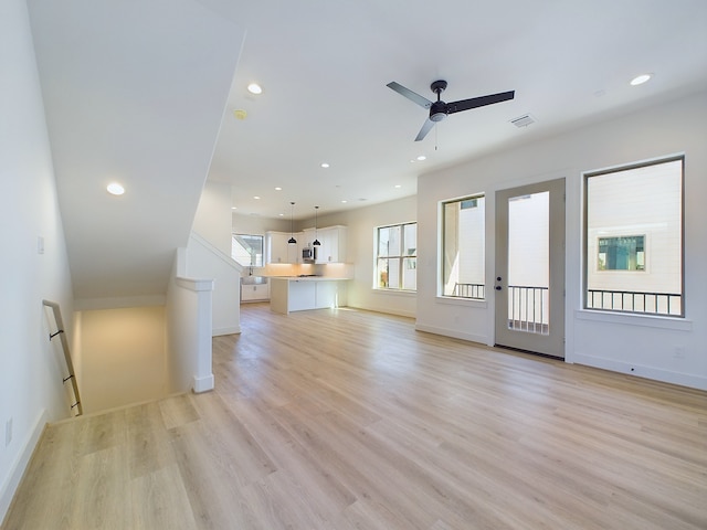 unfurnished living room featuring ceiling fan and light hardwood / wood-style flooring