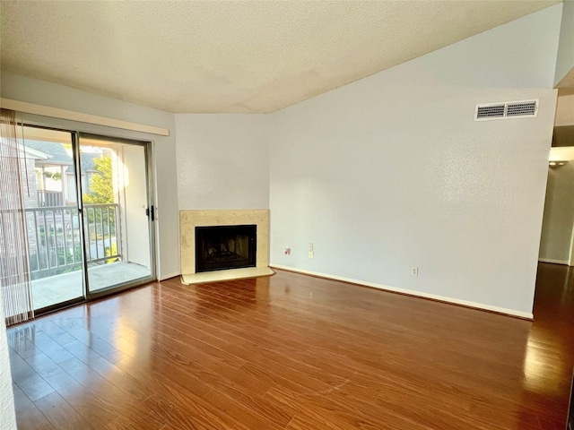 unfurnished living room with a textured ceiling and dark hardwood / wood-style floors