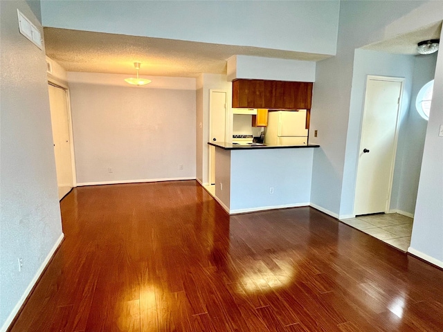 kitchen featuring light hardwood / wood-style flooring, a textured ceiling, and white refrigerator