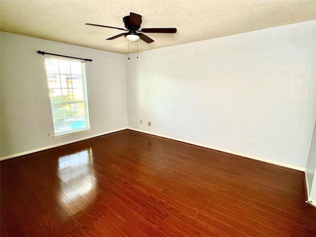 empty room featuring a textured ceiling, dark hardwood / wood-style floors, and ceiling fan