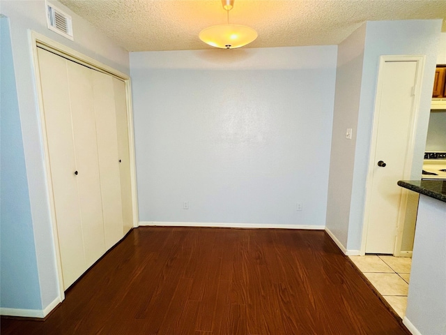 corridor featuring a textured ceiling and light hardwood / wood-style flooring