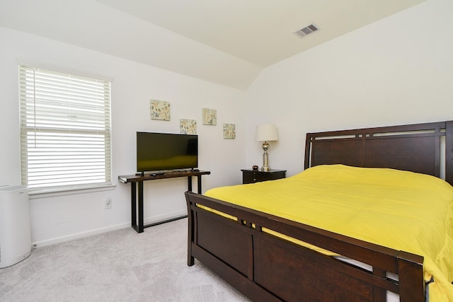 bedroom with light colored carpet and vaulted ceiling