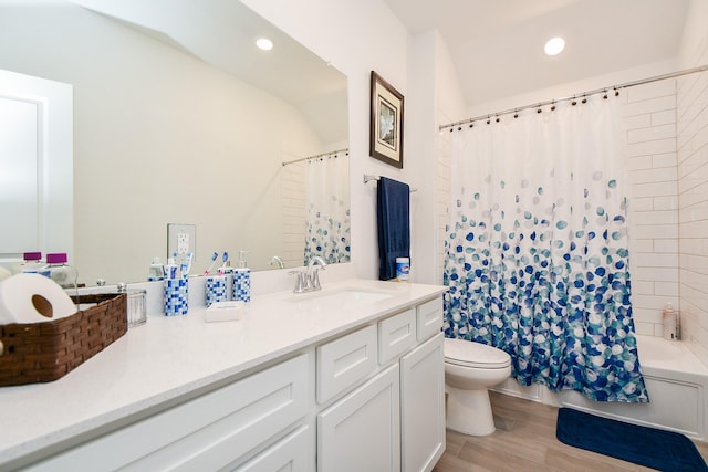 full bathroom featuring wood-type flooring, vanity, shower / tub combo, and toilet