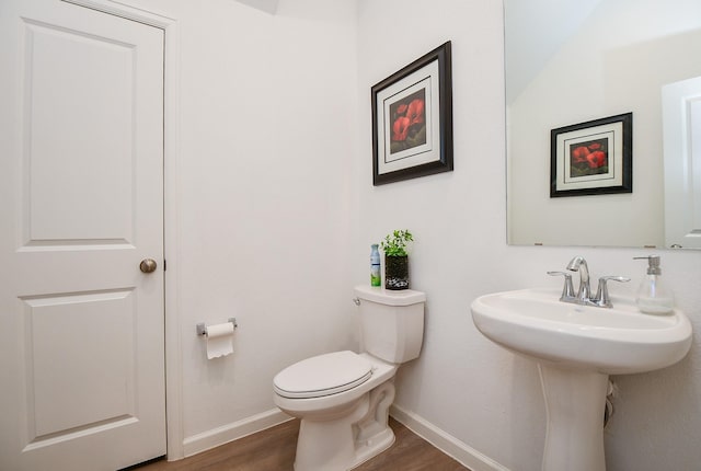 bathroom with hardwood / wood-style floors, toilet, and sink