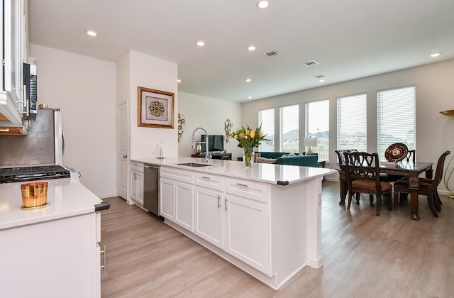 kitchen with white cabinetry, light hardwood / wood-style flooring, sink, and appliances with stainless steel finishes