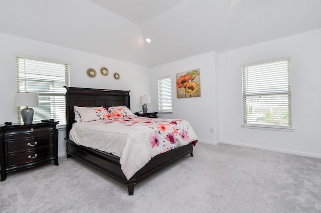 bedroom with light colored carpet and lofted ceiling