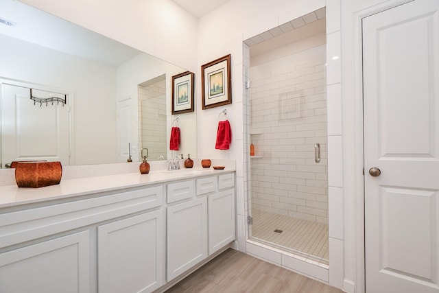 bathroom featuring vanity, hardwood / wood-style flooring, and a shower with door