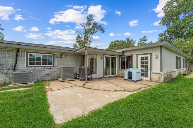 rear view of property featuring a lawn, a patio area, and central AC unit