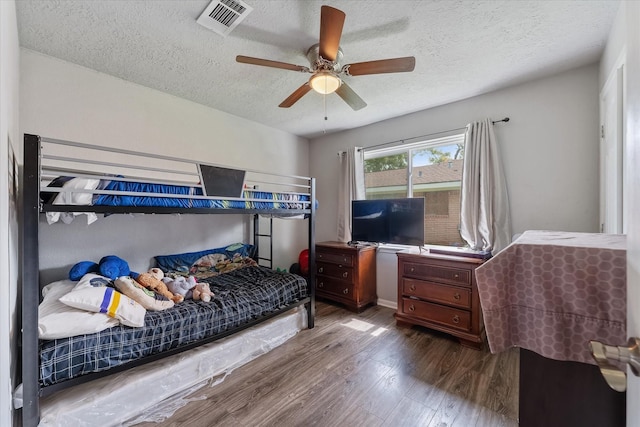 bedroom featuring ceiling fan, wood-type flooring, and a textured ceiling