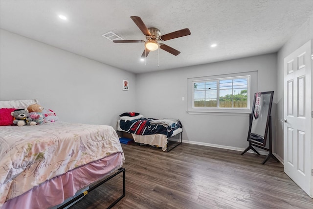 bedroom featuring a textured ceiling, ceiling fan, and dark wood-type flooring