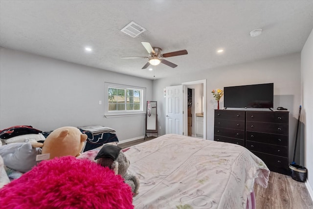 bedroom with wood-type flooring, a textured ceiling, and ceiling fan