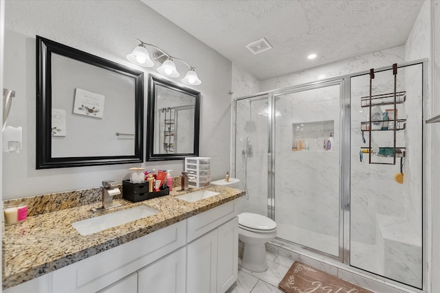 bathroom with vanity, a shower with shower door, a textured ceiling, and toilet