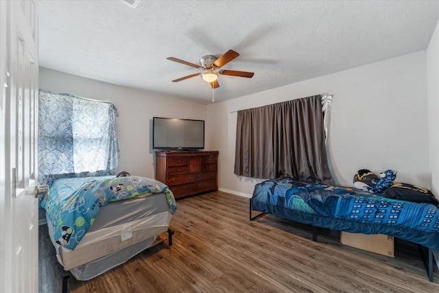 bedroom featuring wood-type flooring, a textured ceiling, and ceiling fan