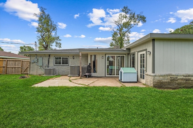 rear view of property featuring a yard, a patio, and central AC unit