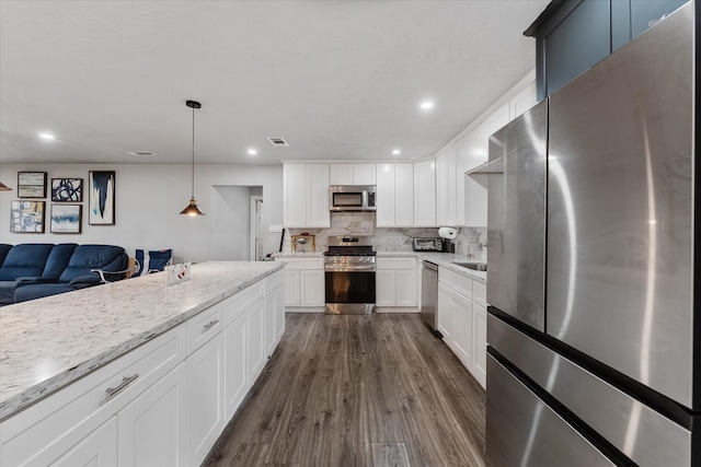 kitchen featuring decorative backsplash, dark hardwood / wood-style flooring, white cabinets, and stainless steel appliances