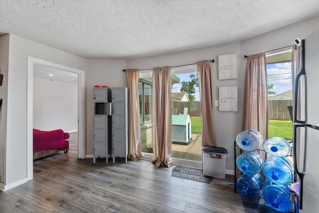 doorway to outside featuring dark wood-type flooring and a textured ceiling