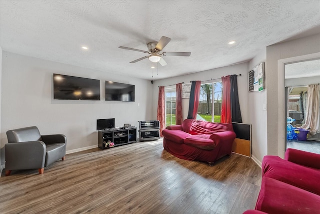 living room with a textured ceiling, hardwood / wood-style flooring, and ceiling fan