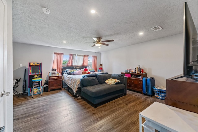 bedroom featuring ceiling fan, dark hardwood / wood-style flooring, and a textured ceiling