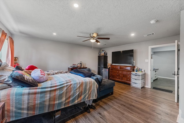 bedroom featuring hardwood / wood-style flooring, ceiling fan, and a textured ceiling