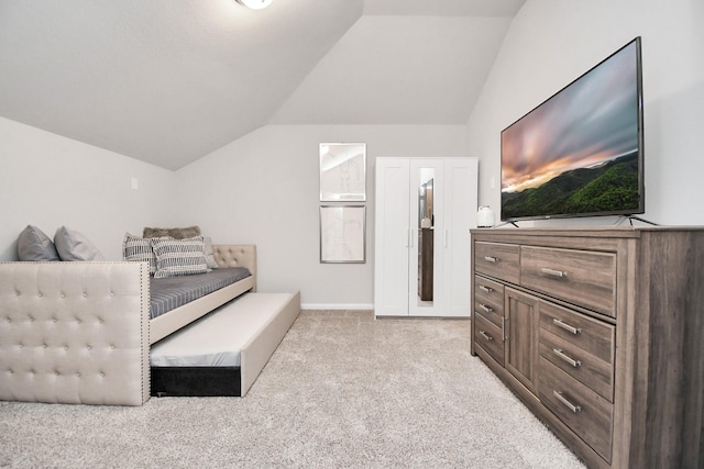 bedroom with light colored carpet and vaulted ceiling