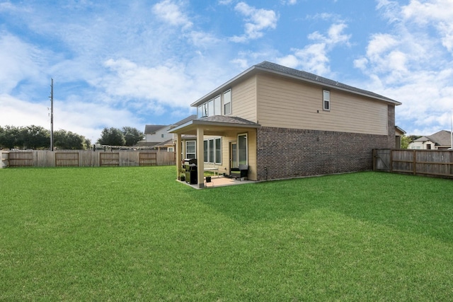 rear view of house with a patio area and a yard